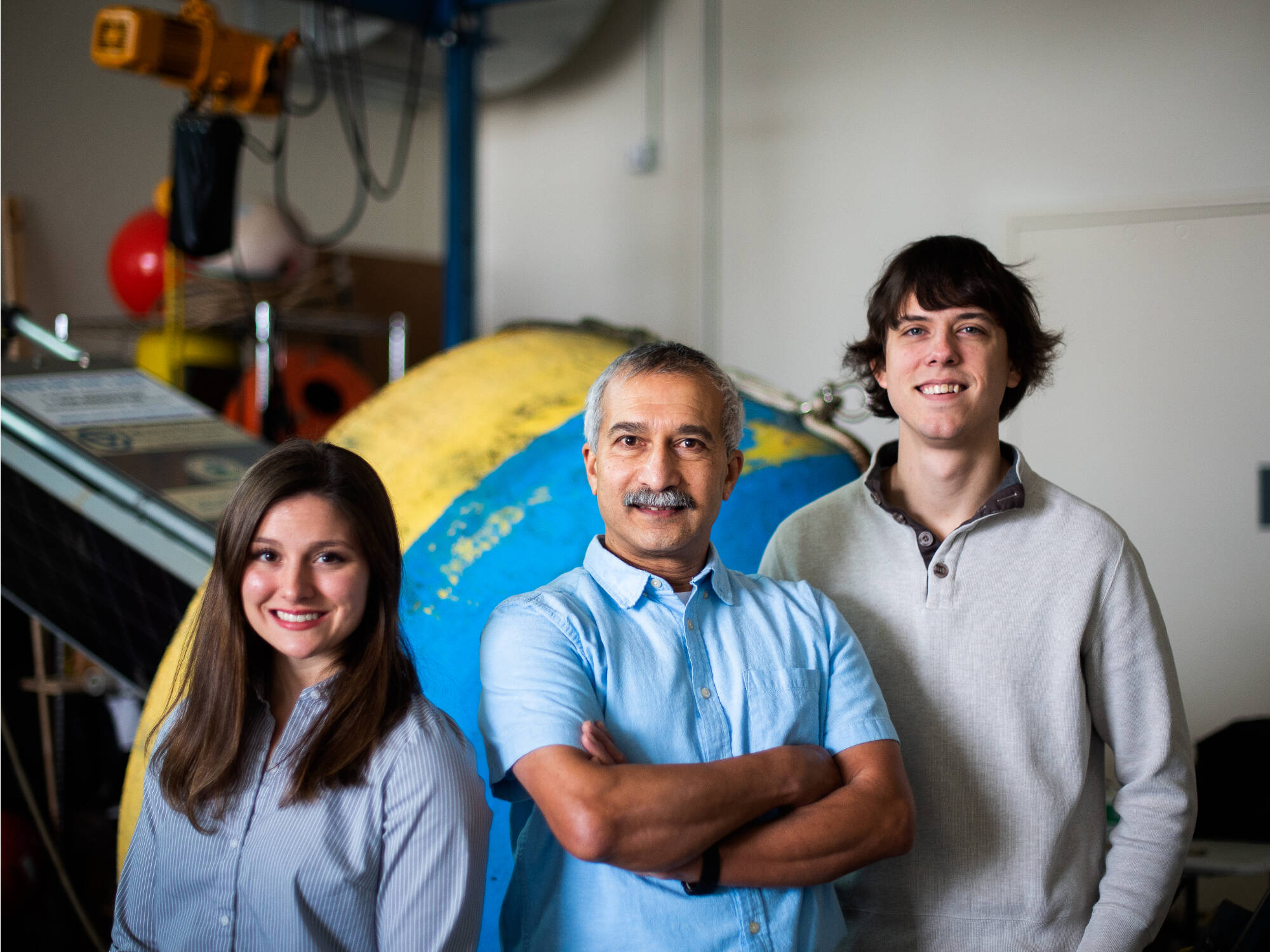 Jasmine Mancuso, Dr. Bopi Biddanda, and Anthony Weinke pose in front of the Muskegon Lake Observatory Buoy.